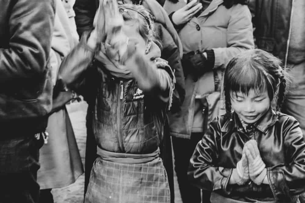 Children praying Jokhang Temple Tibet